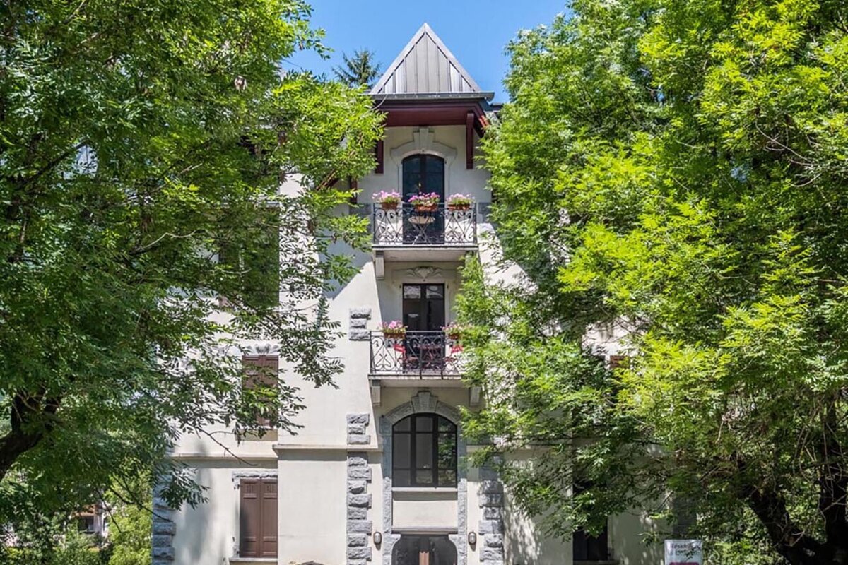 A white building with a balcony and flowers on it