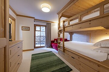 A bedroom with bunk beds and a red couch