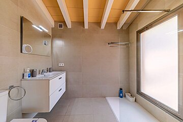 A bathroom with a walk in shower and a sink
