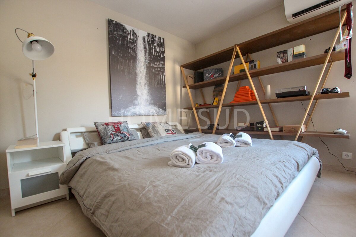 A bedroom with a waterfall painting above the bed