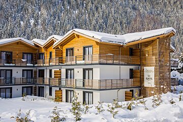 A building with a sign that says oasis is surrounded by snow