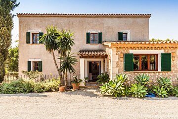 The front of a house with green shutters on the windows
