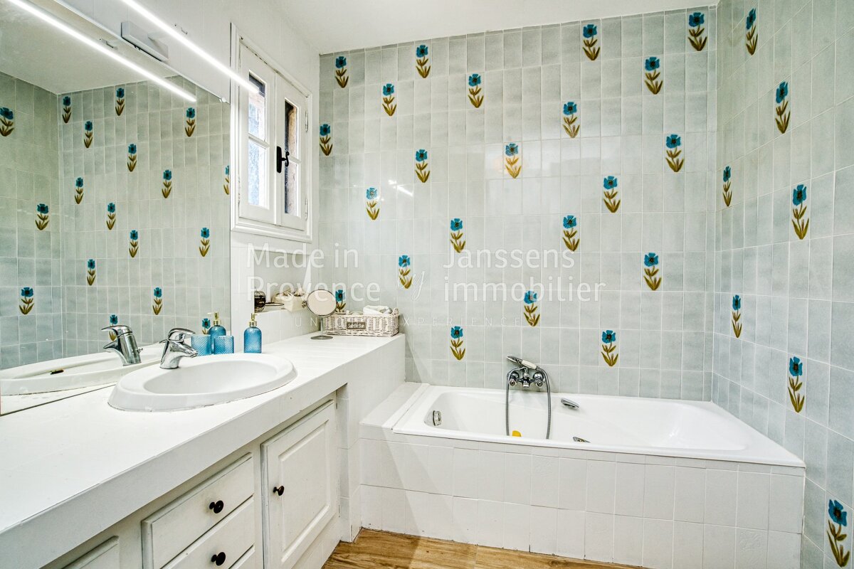 A bathroom with a bathtub and a sink and the words made in provence on the wall