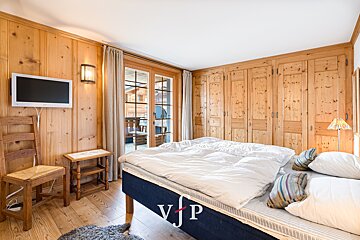 A bedroom with a bed and a tv and the letter vjp on the bed