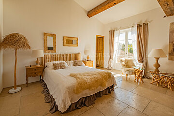 A bedroom with a bed and a chair with a blanket on it