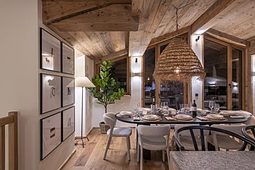 A dining room with a table and chairs and a lamp
