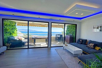 A living room with a pool table and a view of the ocean