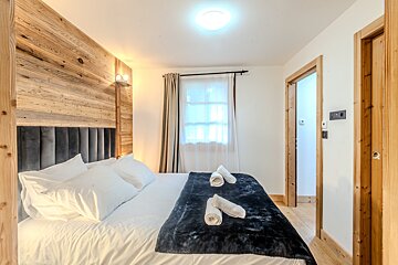 A bedroom with a king size bed and a wooden headboard