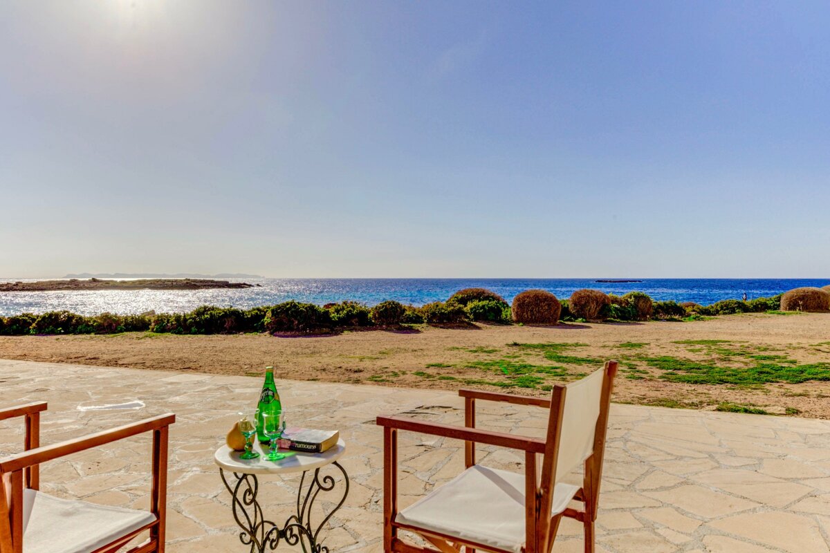 A bottle of perrier sits on a table next to two chairs