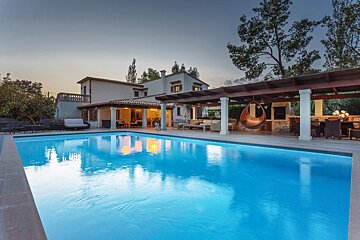 A large house with a large swimming pool in front of it