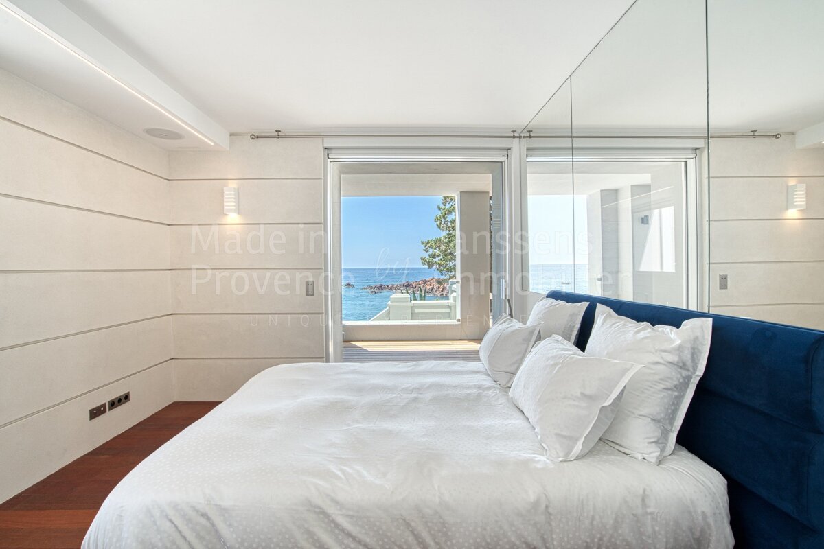 A bedroom with a large bed and a window that says made in provenance