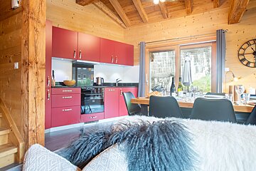 A kitchen with red cabinets and a clock on the wall