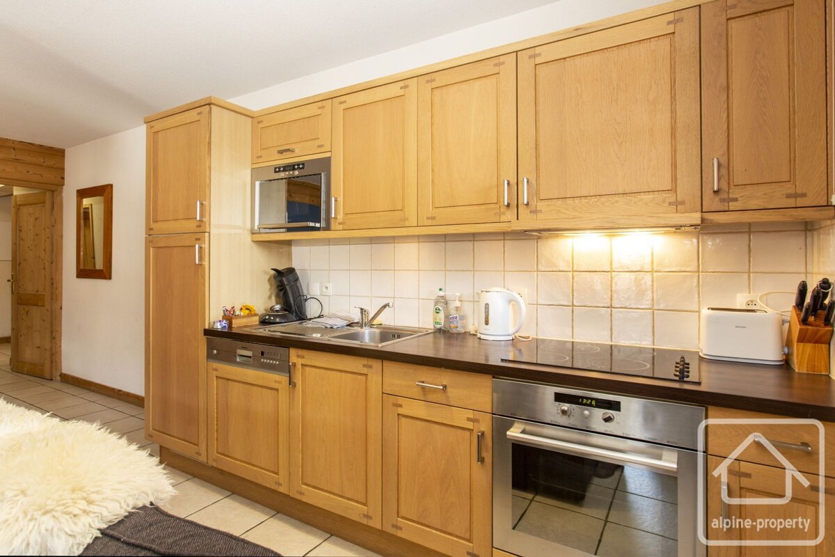 A kitchen with wooden cabinets and stainless steel appliances and a sign that says alpine property