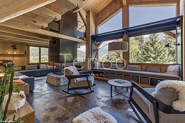 A living room with a rocking chair and a couch with a view of the mountains