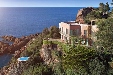 A house sits on a cliff overlooking the ocean