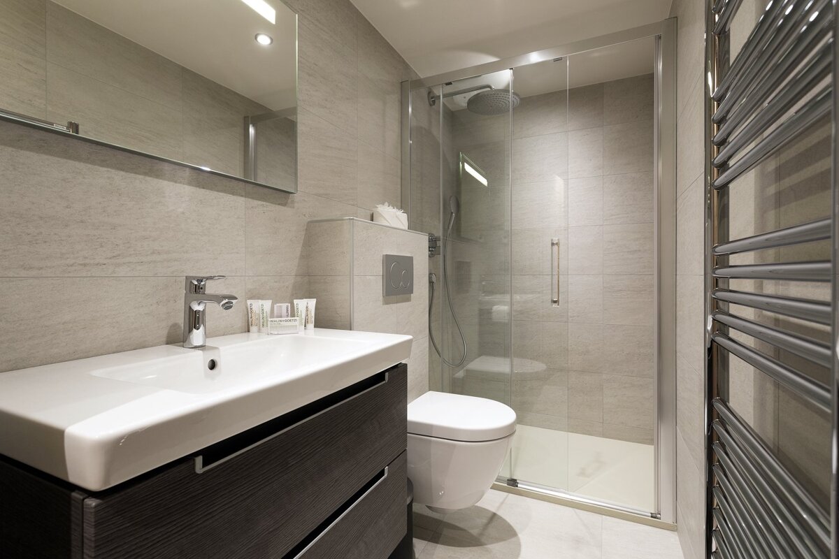 A bathroom with a toilet a sink and a mirror