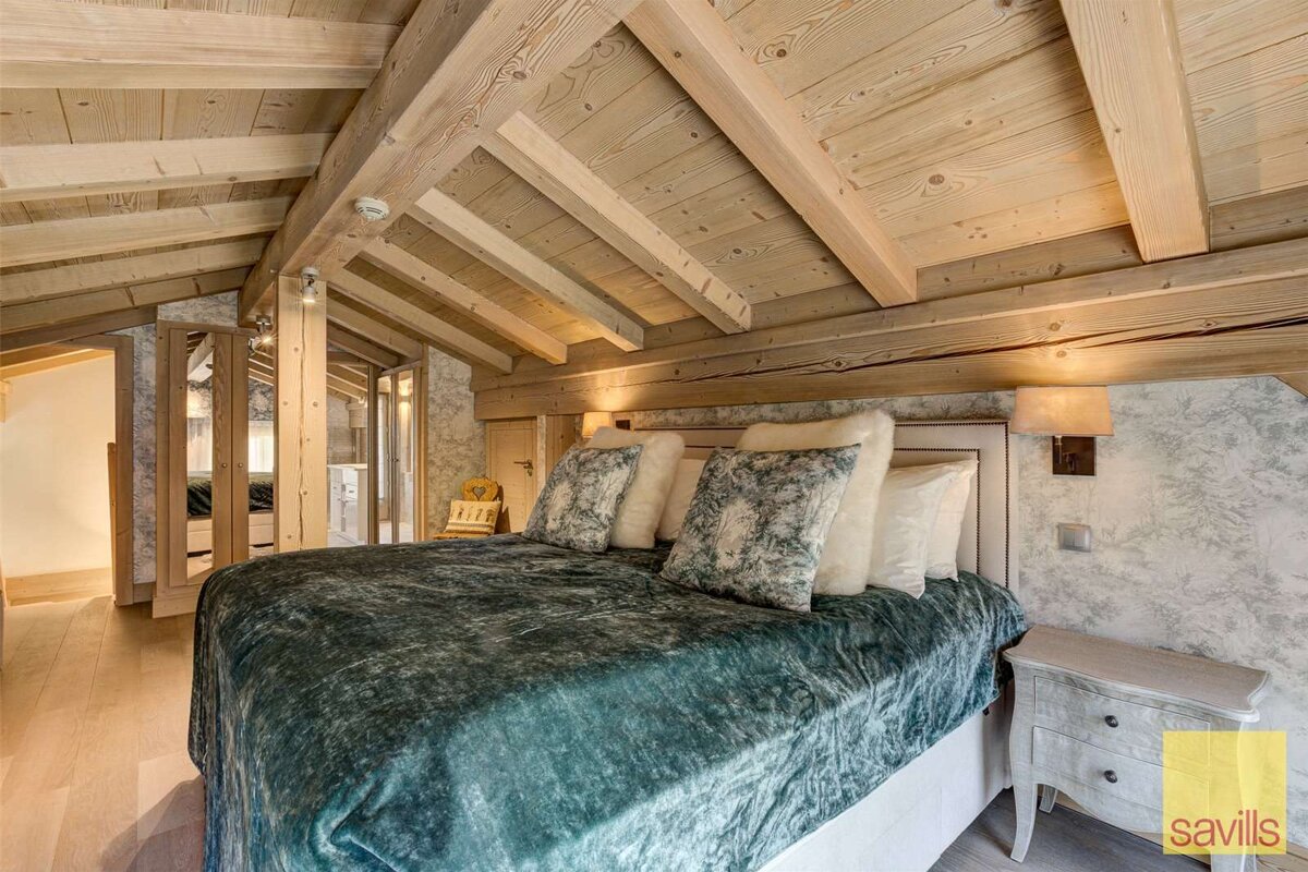 A bedroom with a bed and a sign that says savills