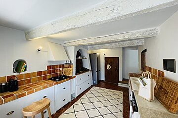 A kitchen with a rug and a bag that says ' l' occitane ' on it