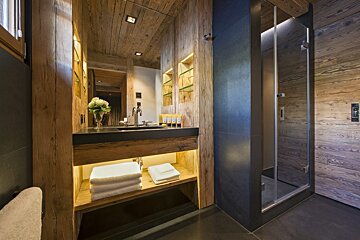 A bathroom with wooden walls and a sink