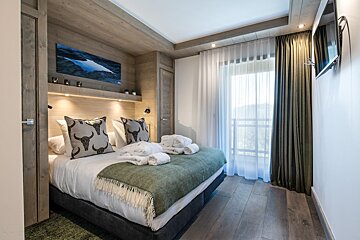 A bedroom with a large bed and a window