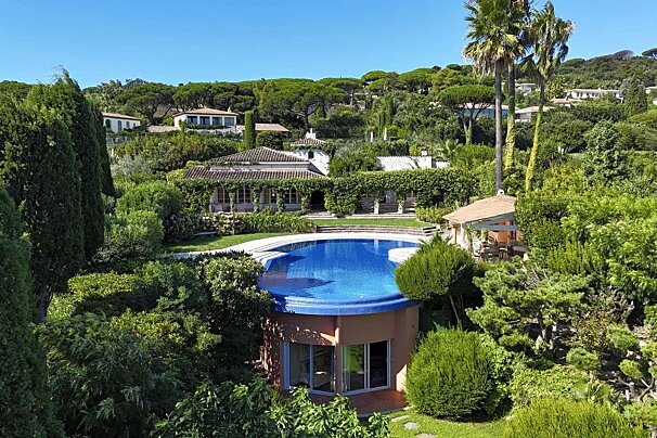 A large house with a swimming pool in front of it