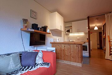 A living room with a couch and a clock on the wall