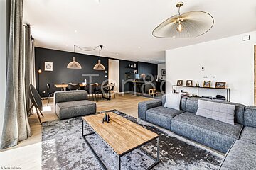 A living room with a gray couch and a wooden coffee table