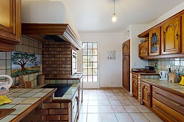 A kitchen with a painting of an olive tree on the wall