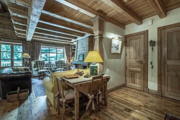 A wooden dining room with a table and chairs