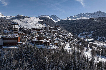 A snowy landscape with mountains in the background