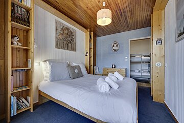 A bunk bed with a picture on the wall above it