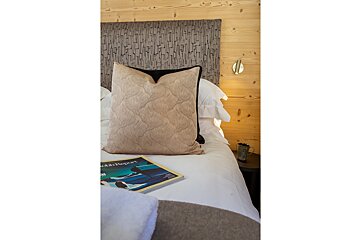 A bed with a pillow and a book on it that says odds report