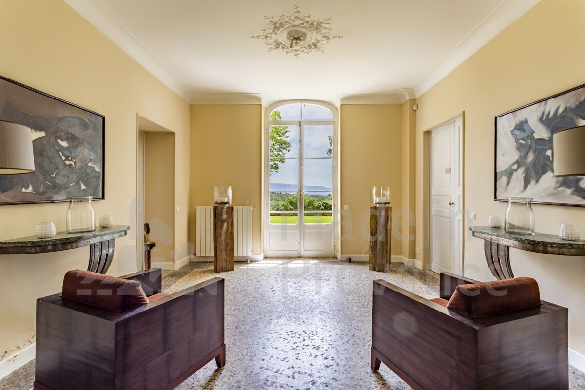 A hallway with two chairs and a painting on the wall