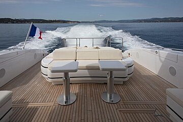The back of a boat with a couch and stools