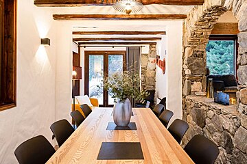 A dining room table with a vase of flowers on it