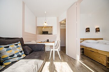 A living room with a couch and a bed