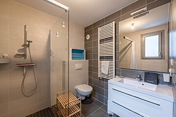 A bathroom with a toilet a sink and a mirror
