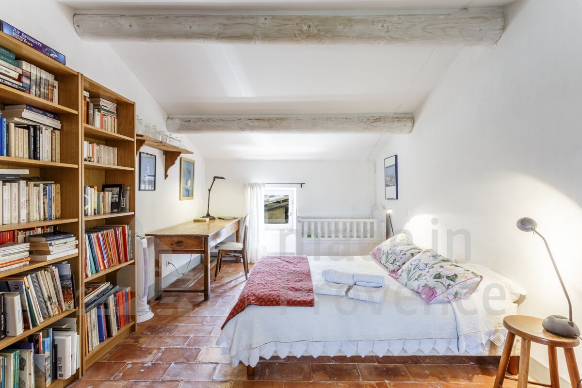 A bedroom with a bed and bookshelves and the word provence in the corner