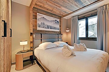 A bedroom with a bed and a picture on the wall