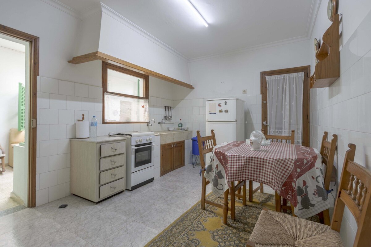 A kitchen with a table and chairs and a refrigerator