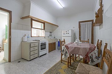 A kitchen with a table and chairs and a refrigerator