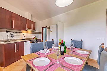 A dining room table with plates and wine bottles on it