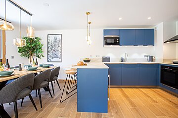 A kitchen with blue cabinets and a picture on the wall