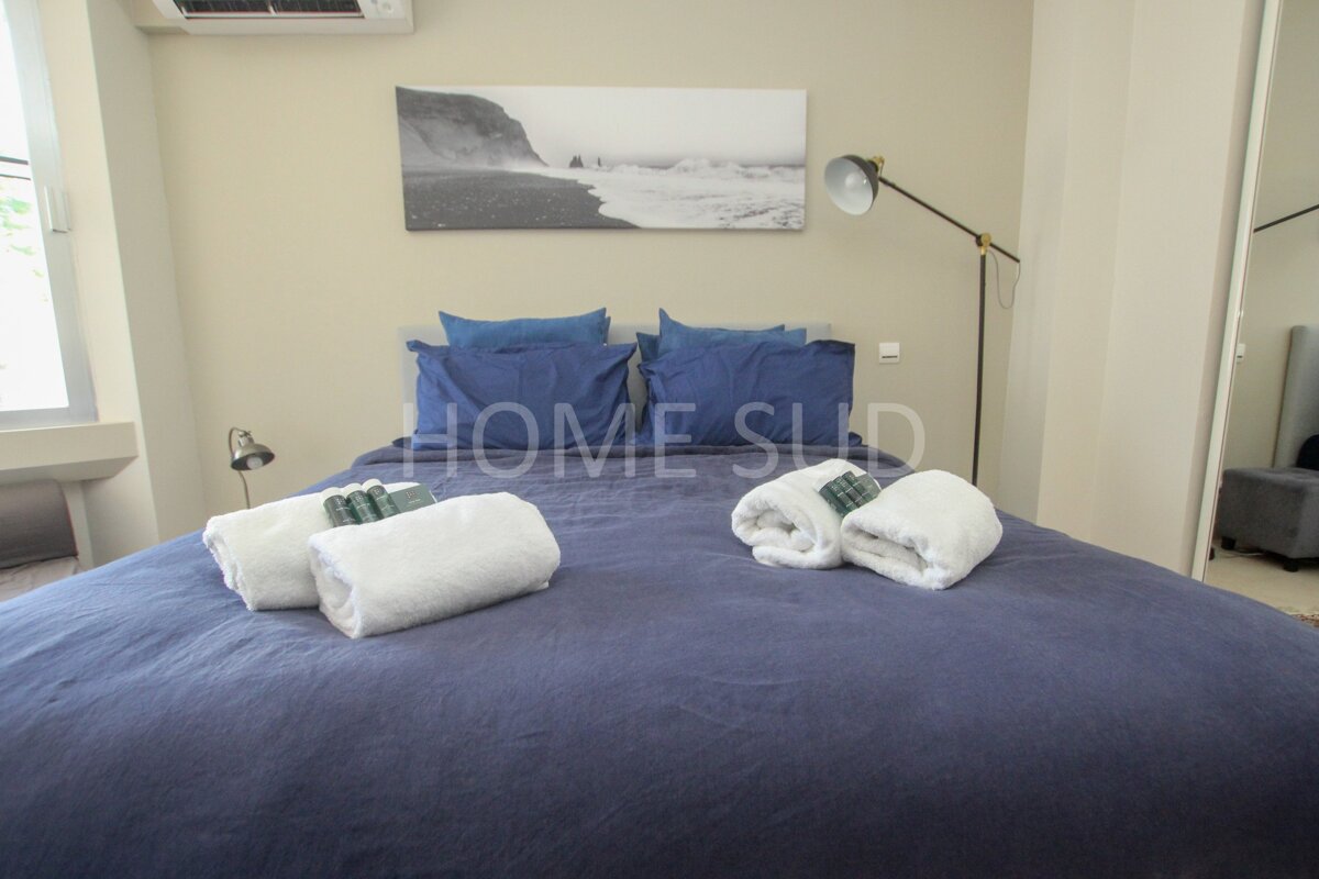 A bedroom with a bed and a painting above it that says home sud