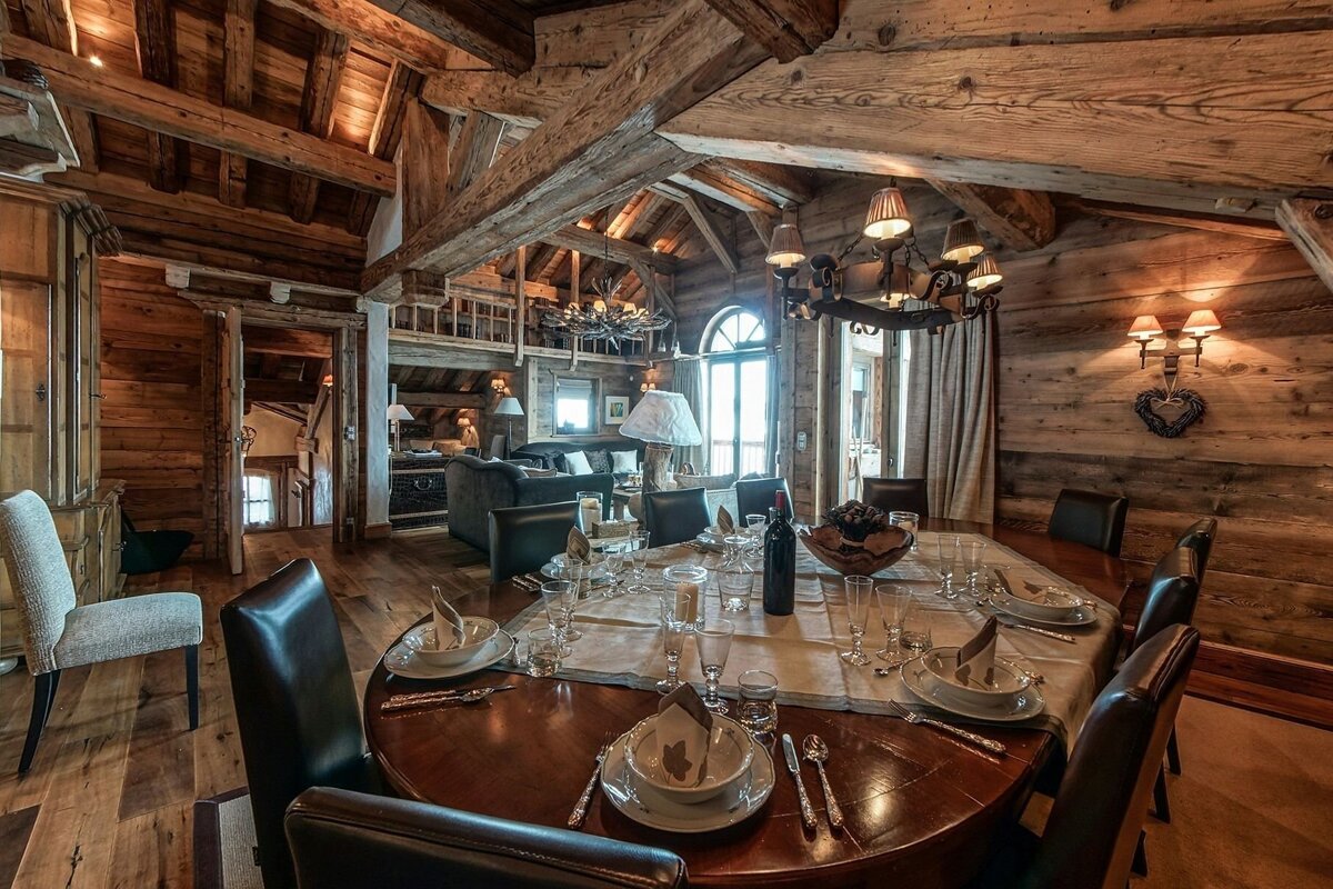 A dining room table with a bottle of wine on it
