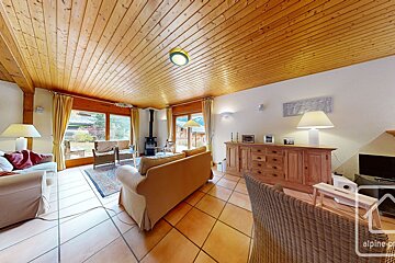 A living room with a wooden ceiling and a sign that says alpine property