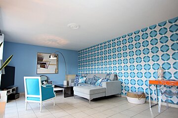 A blue and white living room with a couch and chairs