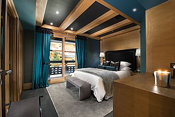 A bedroom with a large bed and blue curtains