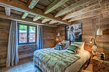 A bedroom with a bed and a picture on the wall