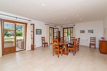 A dining room with a wooden table and chairs